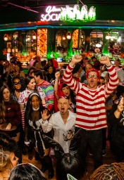group of friends cheering for the camera at the halloween bar crawl