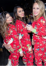 three girls in holiday themed onesies at the ugly christmas sweater bar crawl